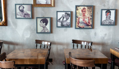 two tables with chairs and portraits on the wall