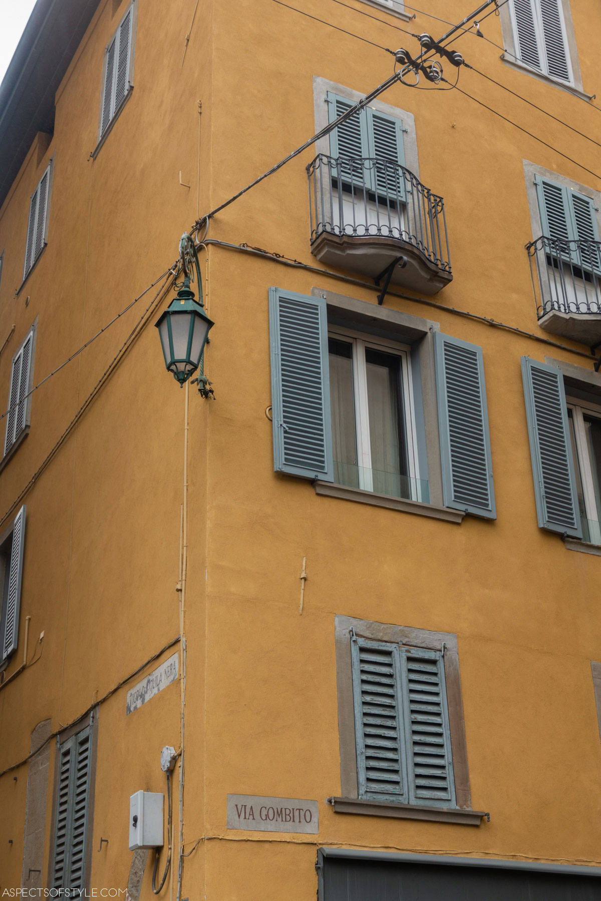 yellow building with light blue wooden shutters in